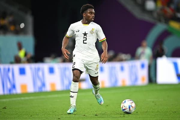 Jugador de Ghana corriendo con el balón en el campo