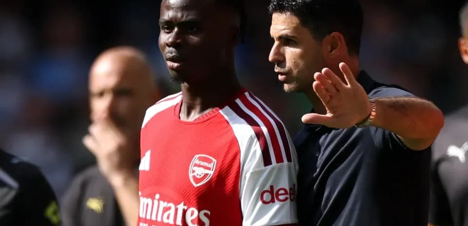 Entrenador de Arsenal hablando con jugador durante partido