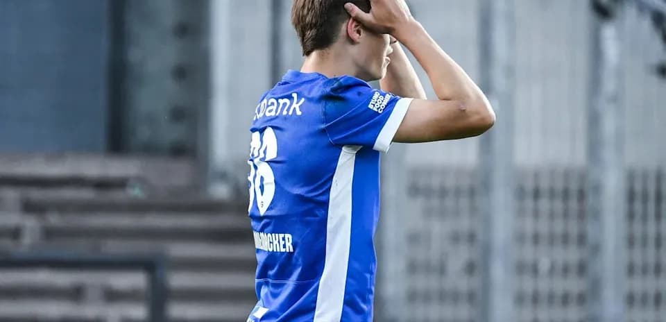 Jugador con camiseta azul, sosteniendo la cabeza