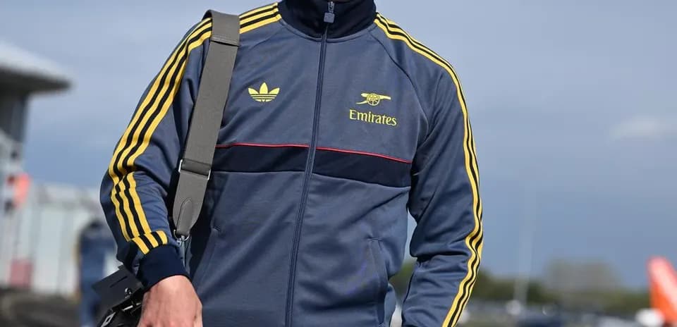 Jugador con chándal caminando en el aeropuerto