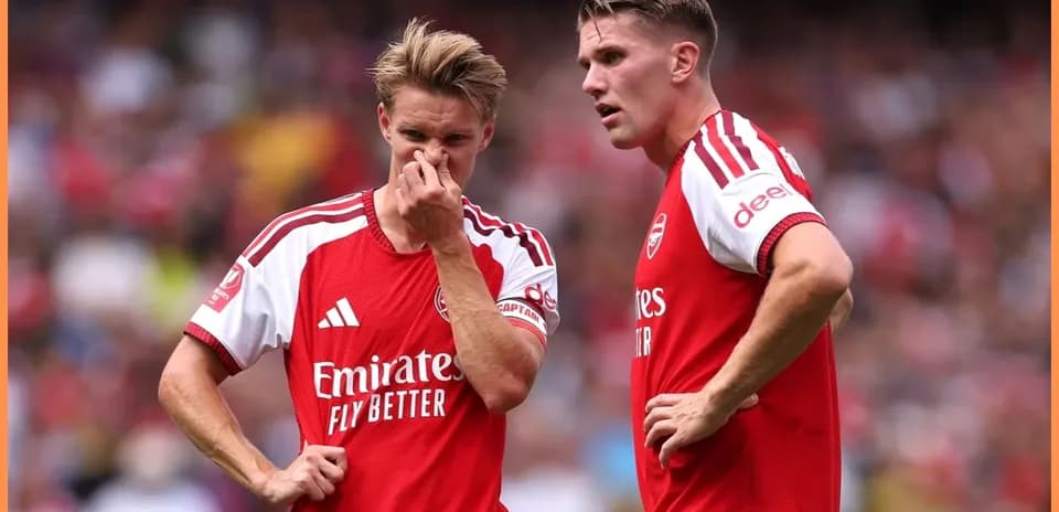 Dos jugadores de Arsenal conversando en el campo