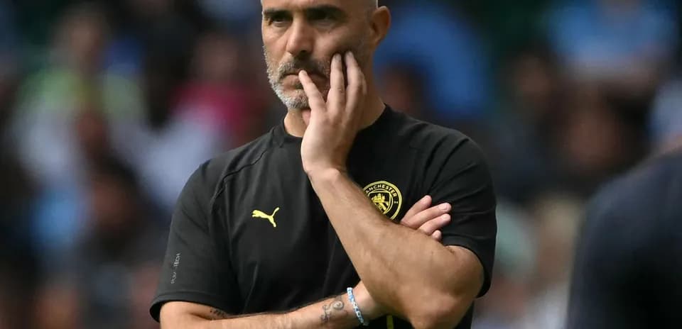 Entrenador observando el partido con expresión pensativa
