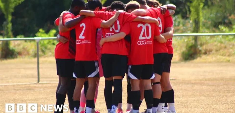 Equipo de fútbol en círculo durante reunión previa