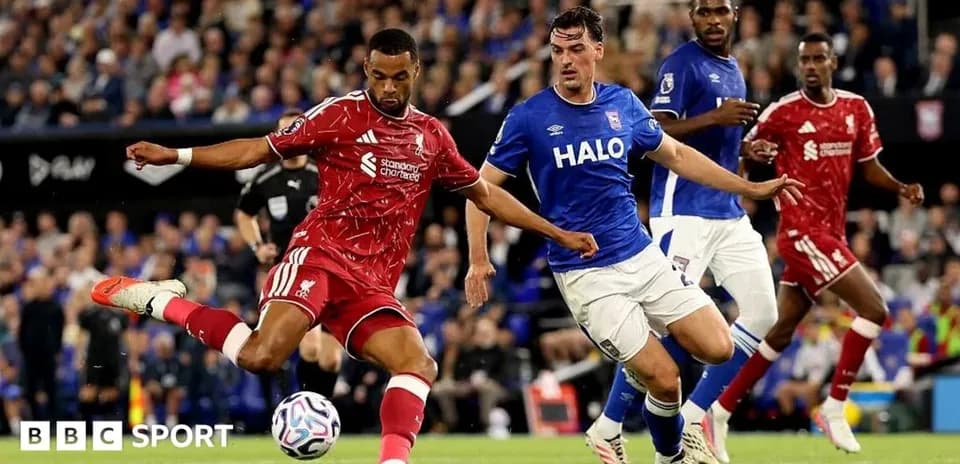 Jugador de Liverpool disparando mientras es defendido