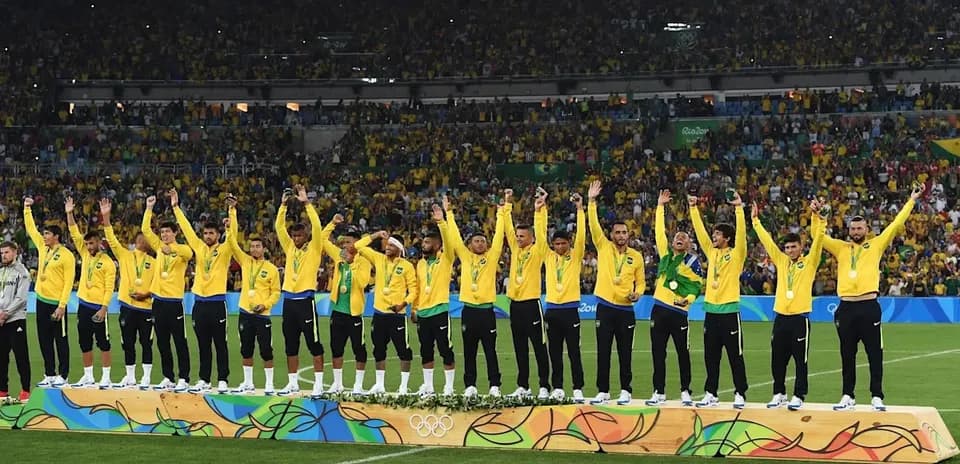Equipo de fútbol de Brasil recibiendo medallas en el podio