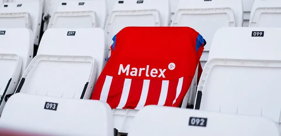 Camisa roja con rayas en asiento vacío de estadio
