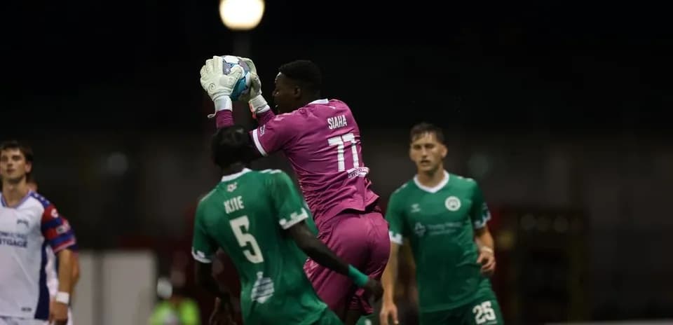 Portero atrapando el balón en un partido