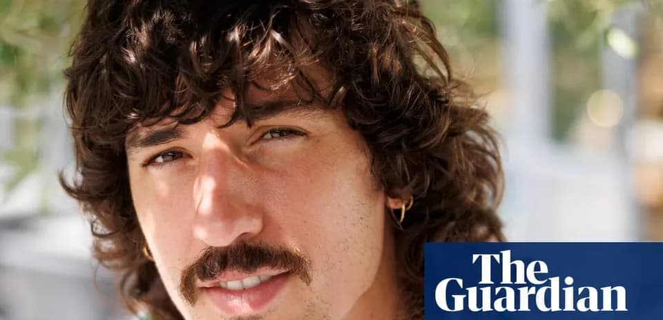 Hombre con cabello rizado y bigote en primer plano
