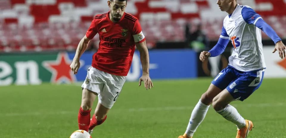 Jugador de Benfica driblando a un rival de Lech Poznan