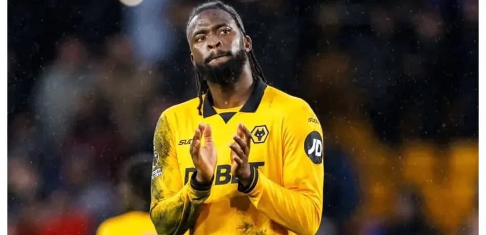 Jugador aplaudiendo en campo de fútbol bajo la lluvia