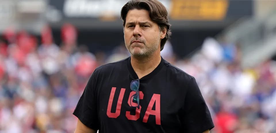 Entrenador con camiseta negra con 'USA' en el estadio