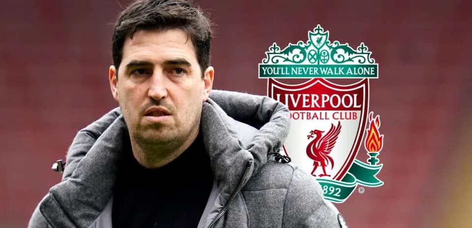Entrenador de Liverpool frente al escudo del club