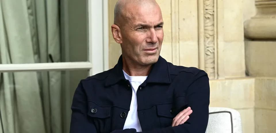 Hombre con camiseta blanca y chaqueta oscura sentado