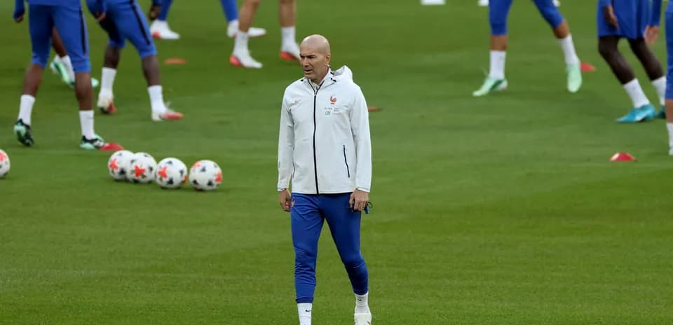 Entrenador observando a jugadores en sesión de entrenamiento