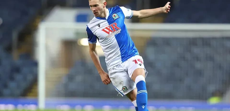 Jugador de Blackburn Rovers pateando el balón en el campo