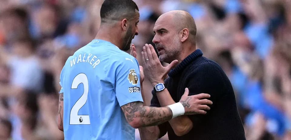 Pep Guardiola hablando con Kyle Walker en el campo