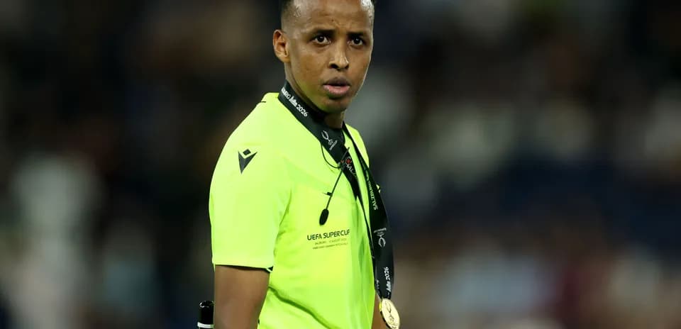 Árbitro con camiseta amarilla y medalla en el cuello