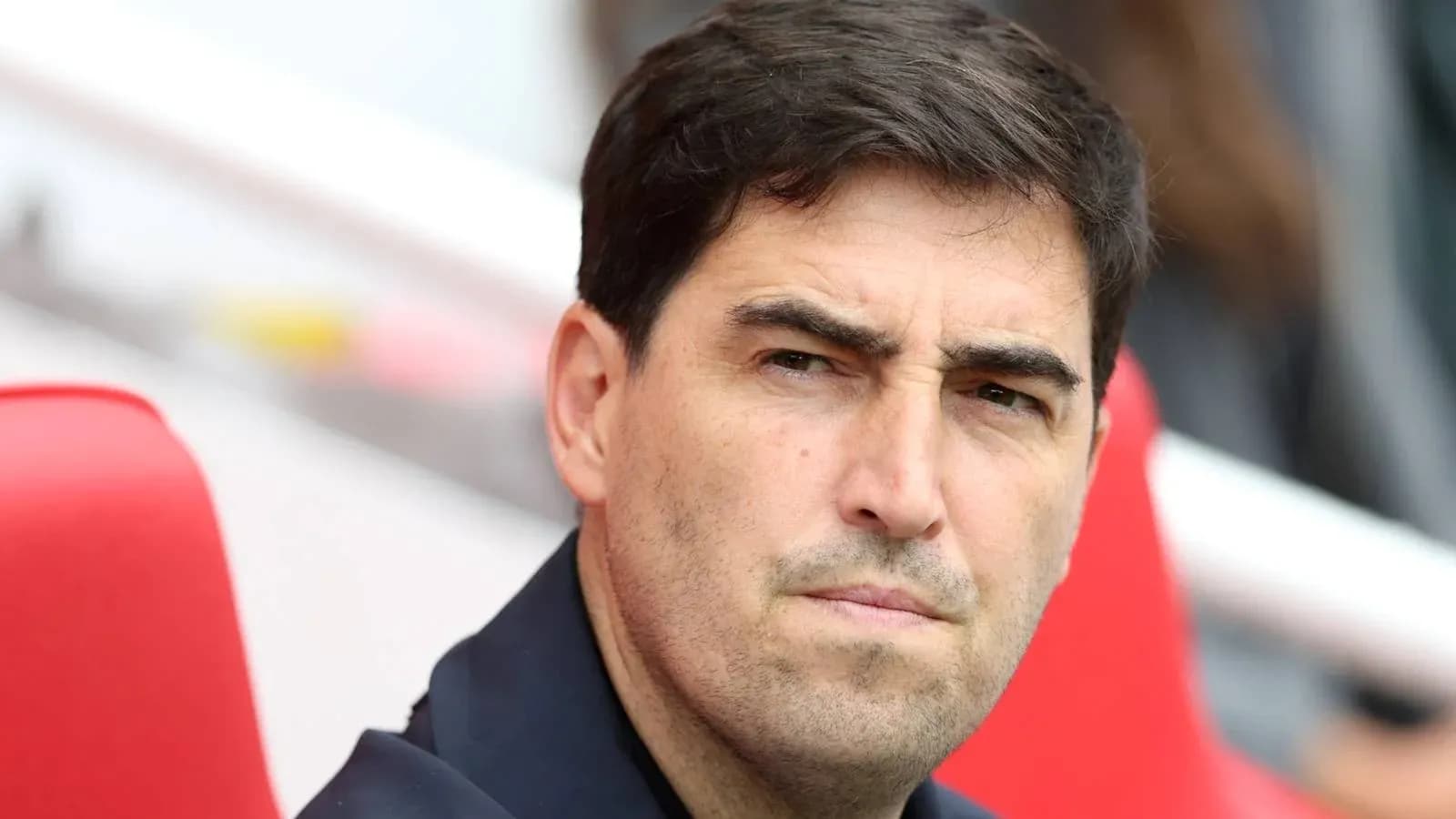 Entrenador sentado en el banquillo durante el partido