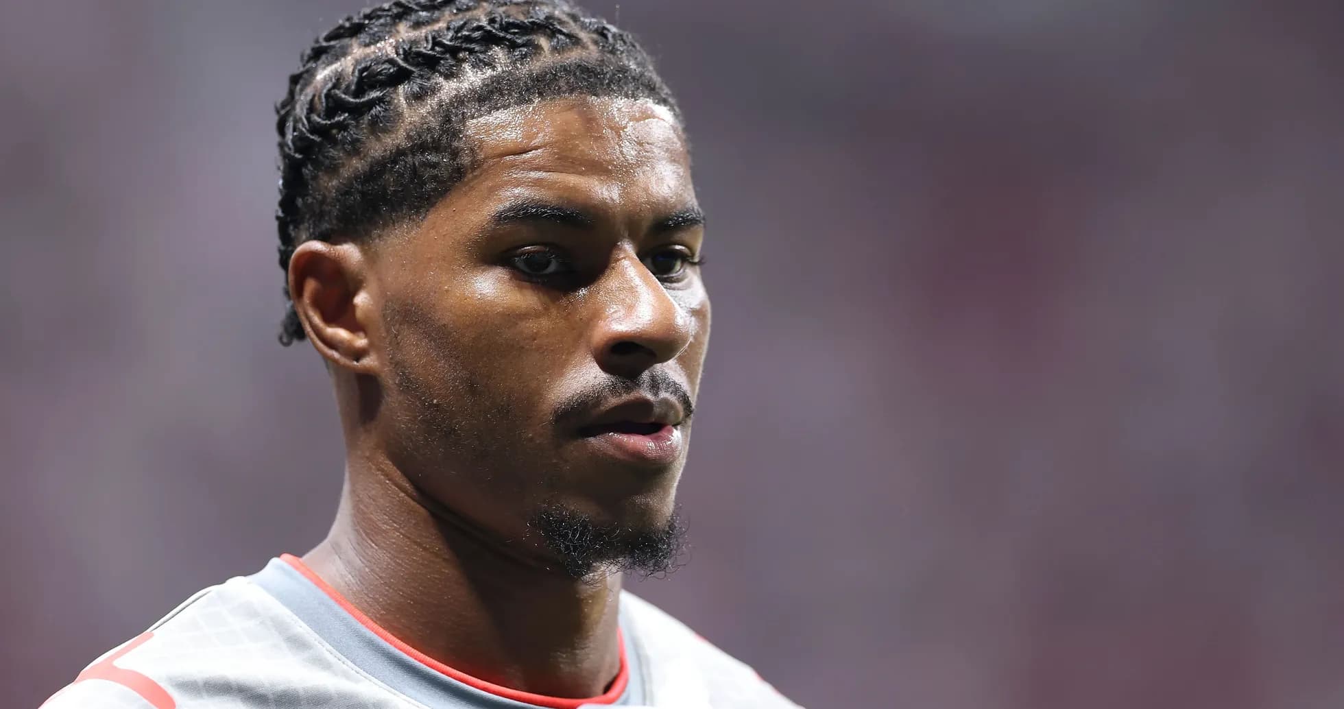 Jugador con trenzas en uniforme gris de fútbol