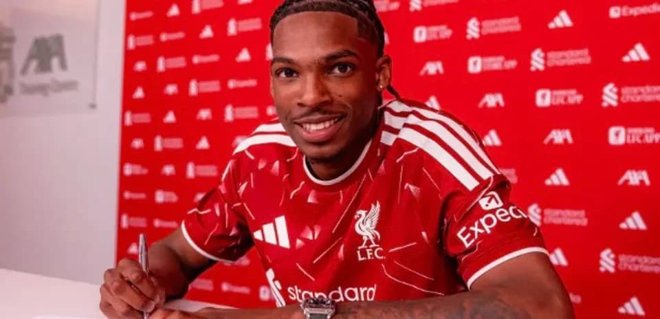 Jugador firmando contrato con Liverpool en conferencia