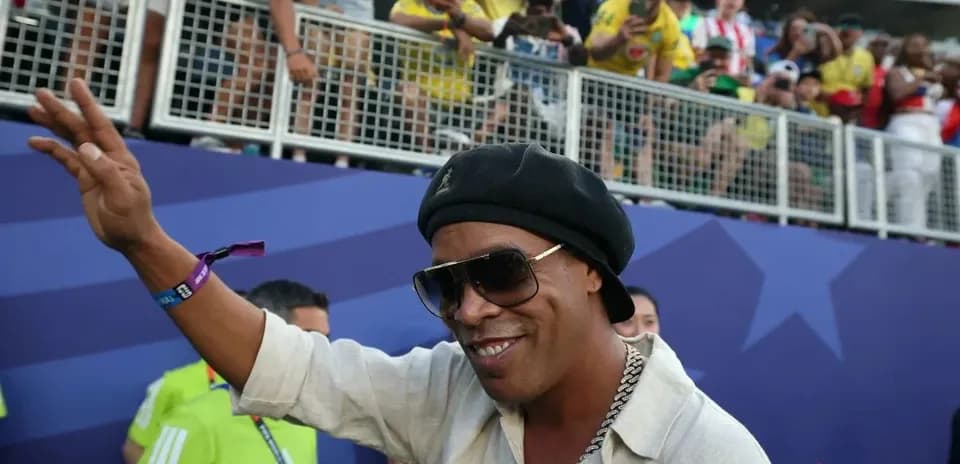 Persona saludando en un evento deportivo con aficionados