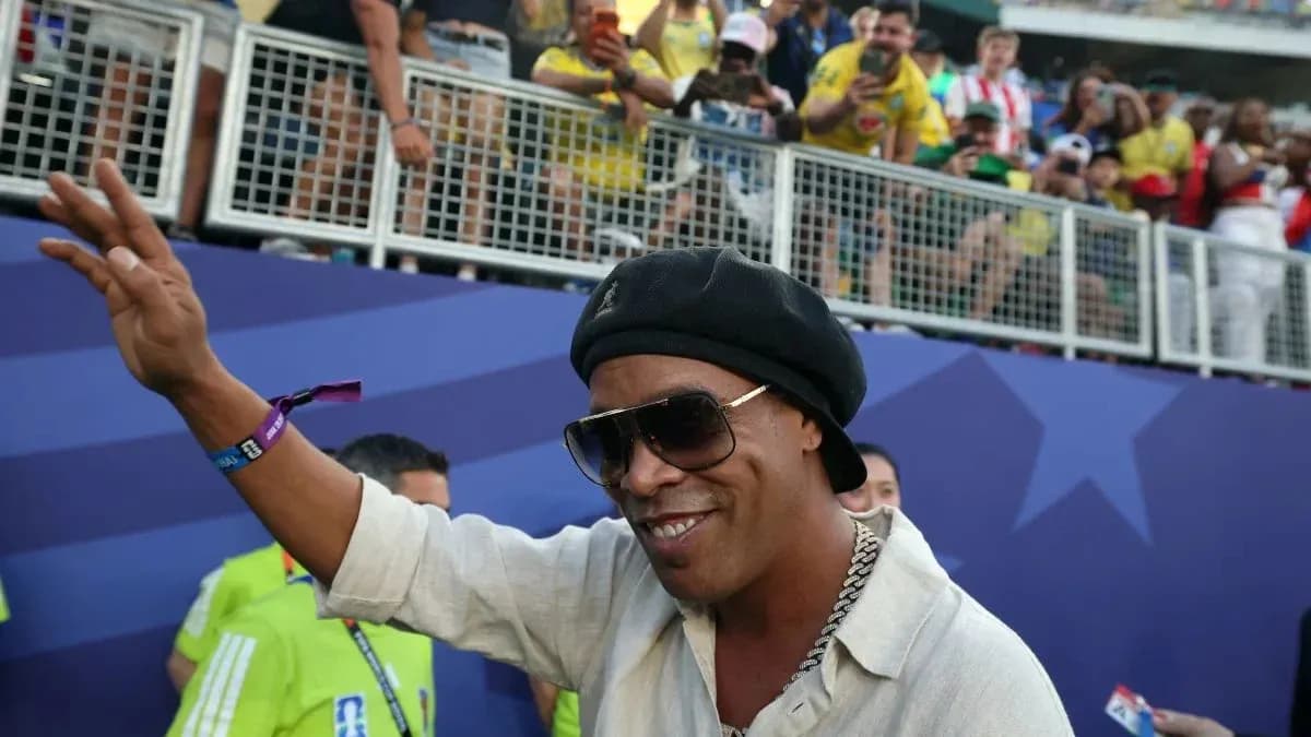 Persona saludando en un evento deportivo con aficionados