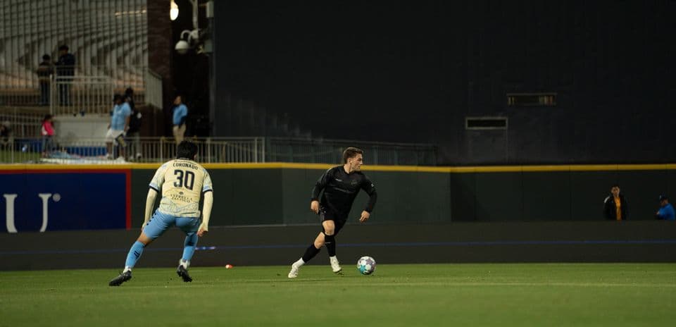 Jugador de Colorado Springs driblando a defensor