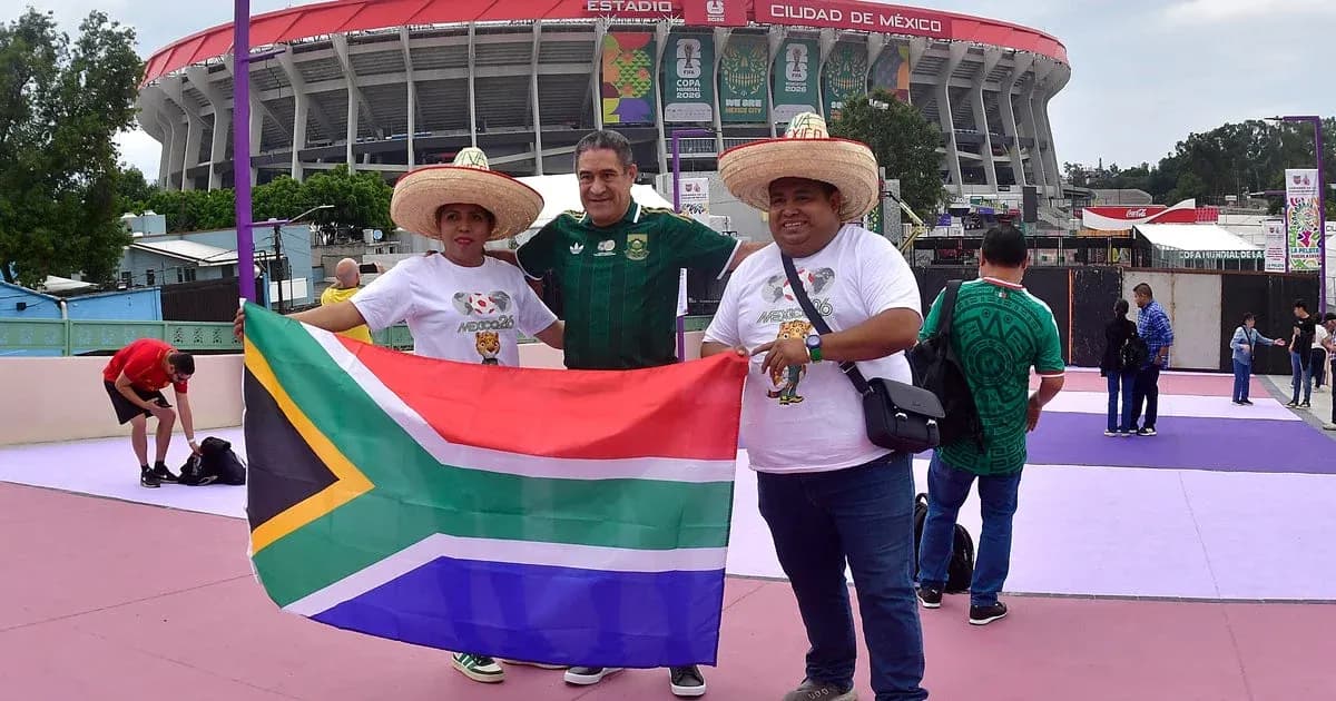 Tres aficionados sosteniendo una bandera de Sudáfrica