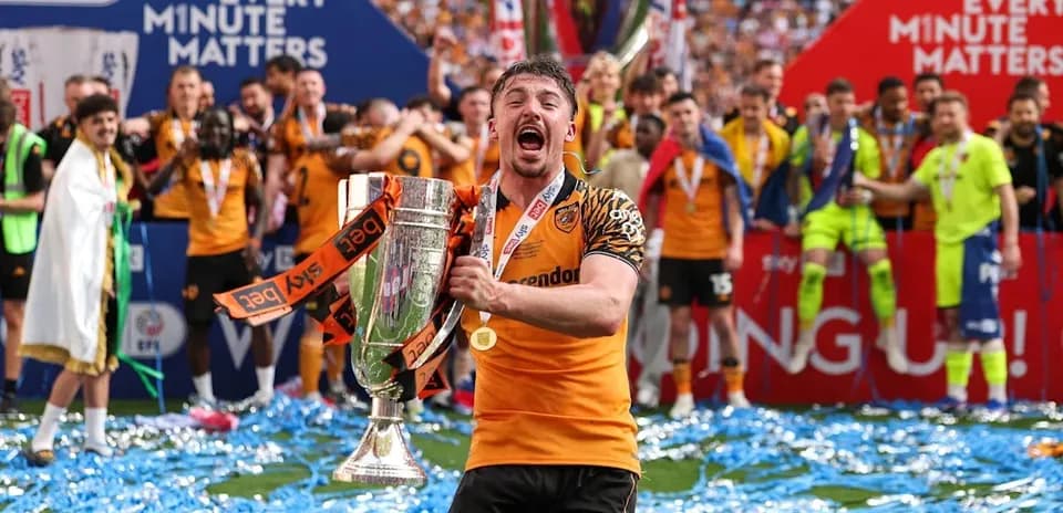 Jugador celebra con trofeo en campo de fútbol