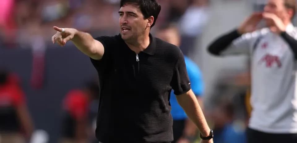 Entrenador dirigiendo desde la línea de banda