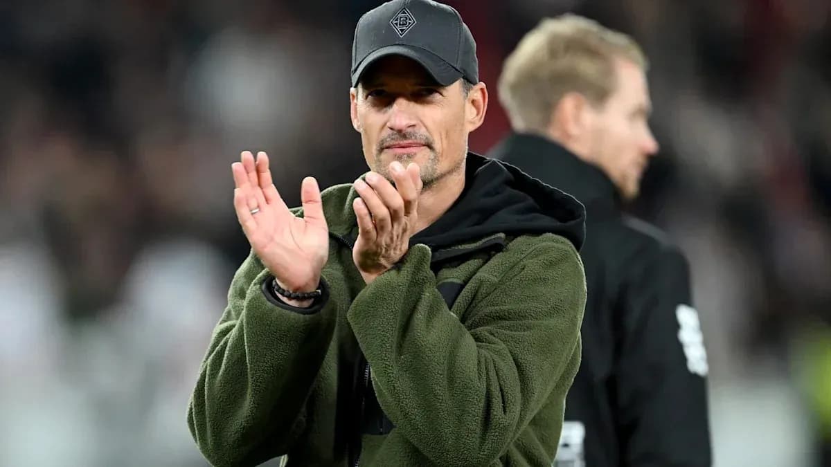 Entrenador aplaudiendo en el banquillo durante el partido
