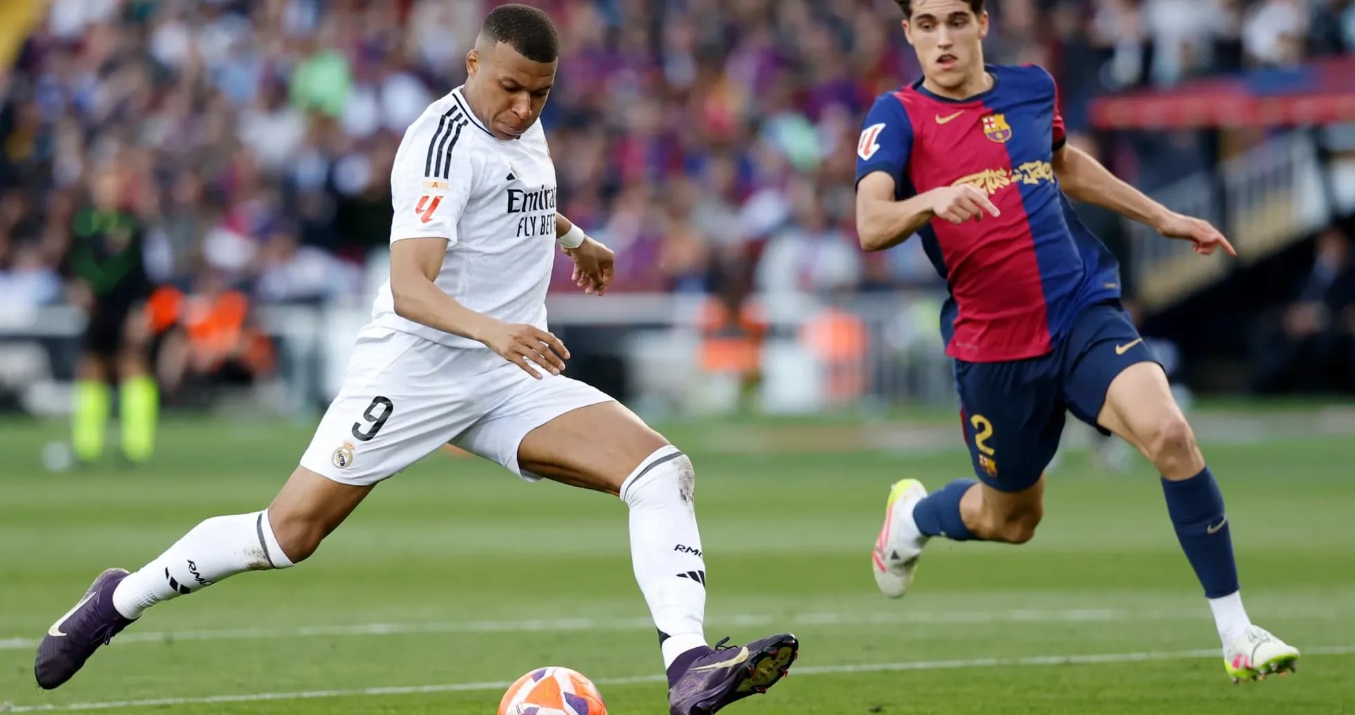 Jugador de Real Madrid driblando a jugador de Barcelona