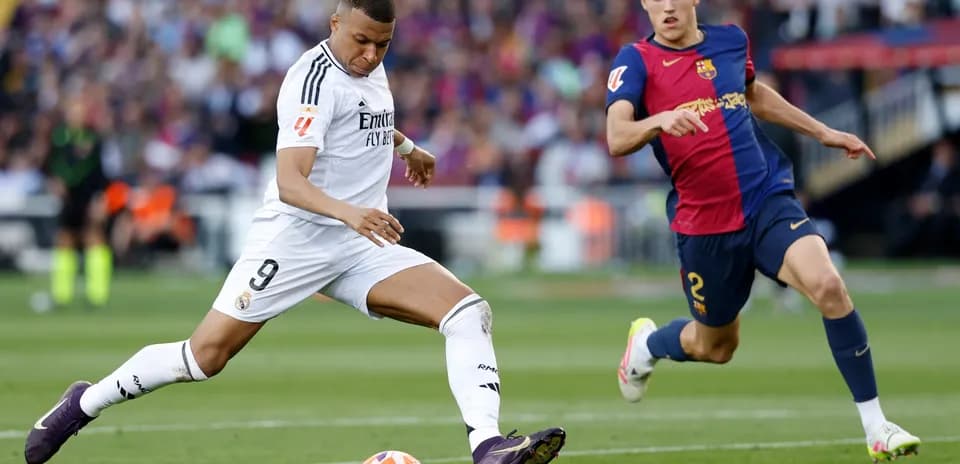 Jugador de Real Madrid driblando a jugador de Barcelona