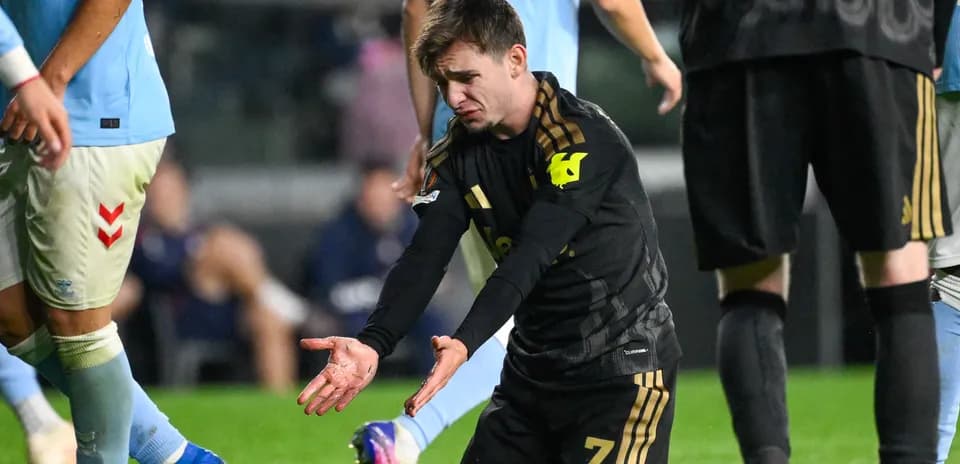 Jugador en uniforme negro gesticulando en el campo