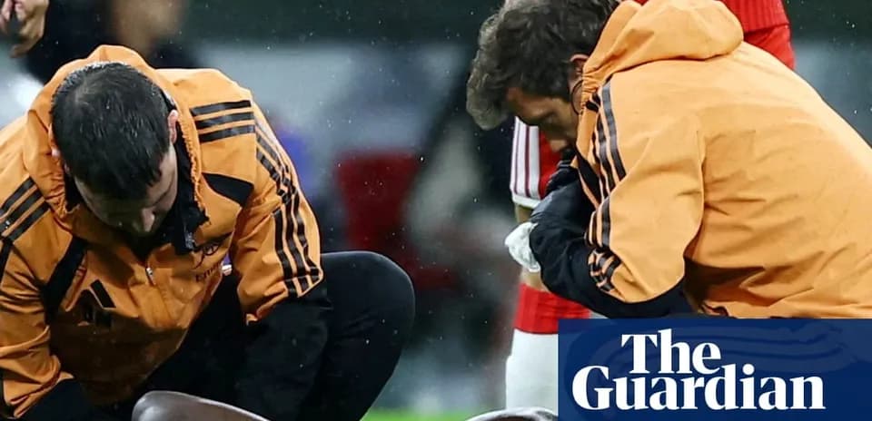 Dos entrenadores atendiendo a un jugador lesionado