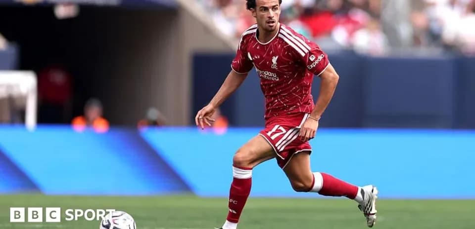 Jugador de Liverpool corriendo con el balón en el campo