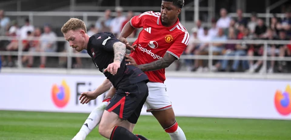 Jugador de Manchester United persiguiendo a oponente en el campo