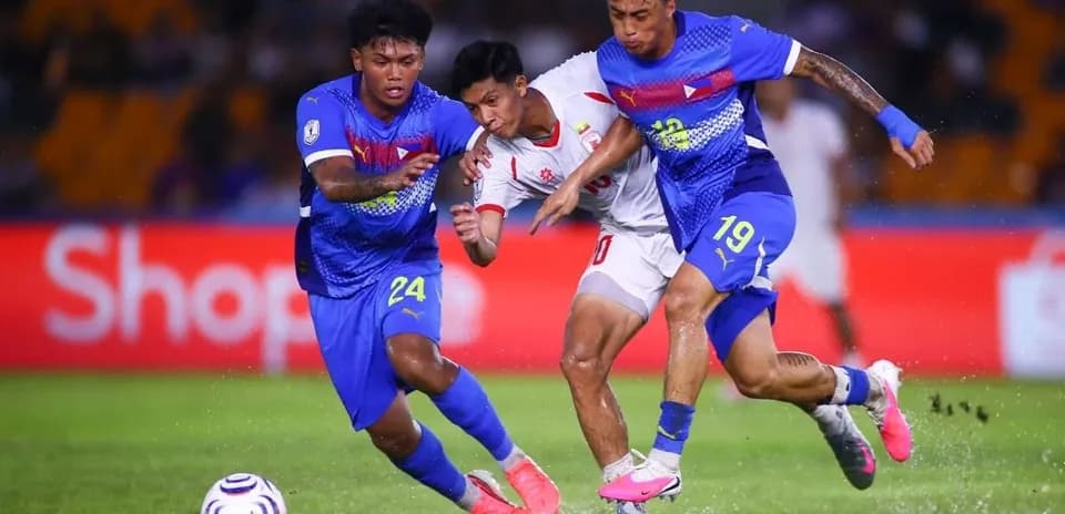Dos jugadores defienden contra un oponente en el partido
