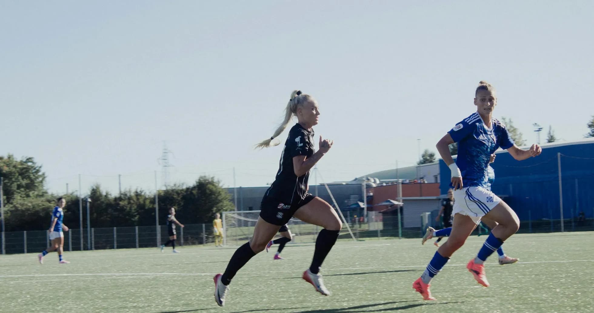 Jugadoras corriendo en un partido de fútbol