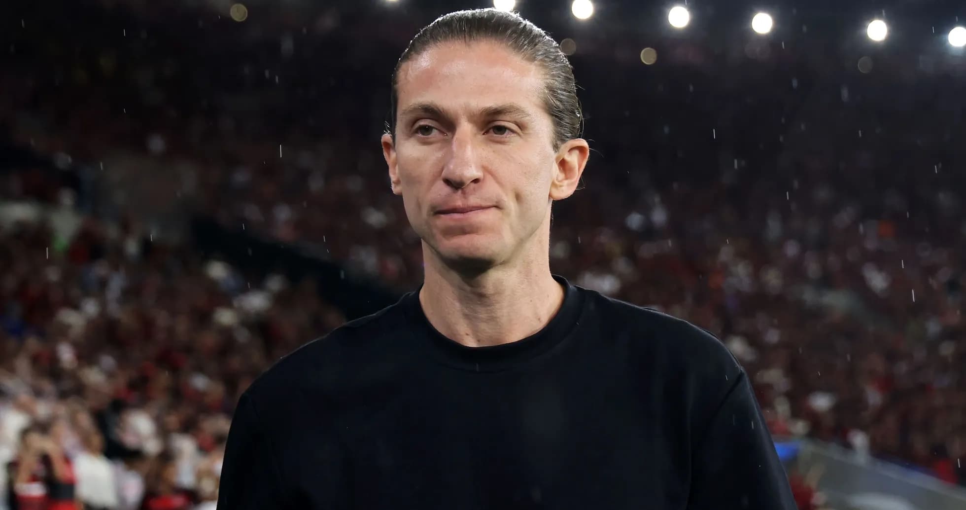 Entrenador en el campo con público al fondo