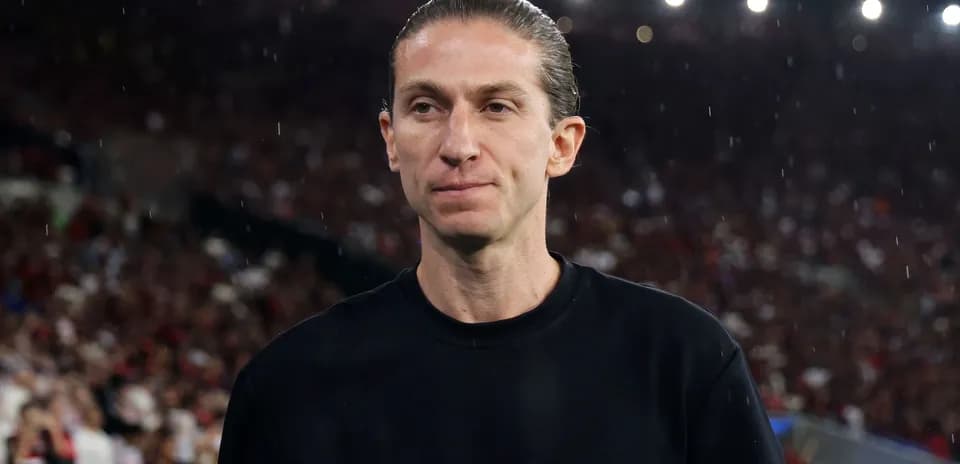 Entrenador en el campo con público al fondo