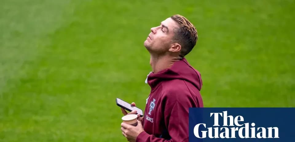 Jugador sosteniendo un teléfono y un vaso en el campo