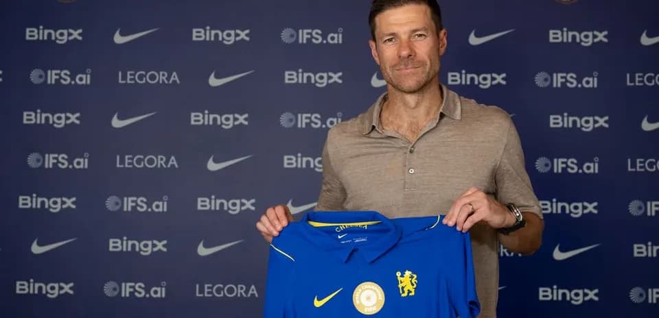 Entrenador sosteniendo camiseta de Chelsea en presentación