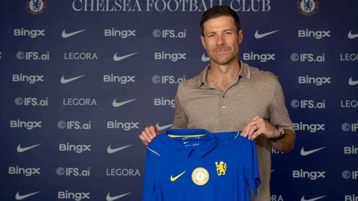 Entrenador sosteniendo camiseta de Chelsea en presentación