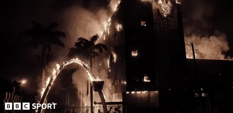 Edificio en llamas con humo y palmeras alrededor
