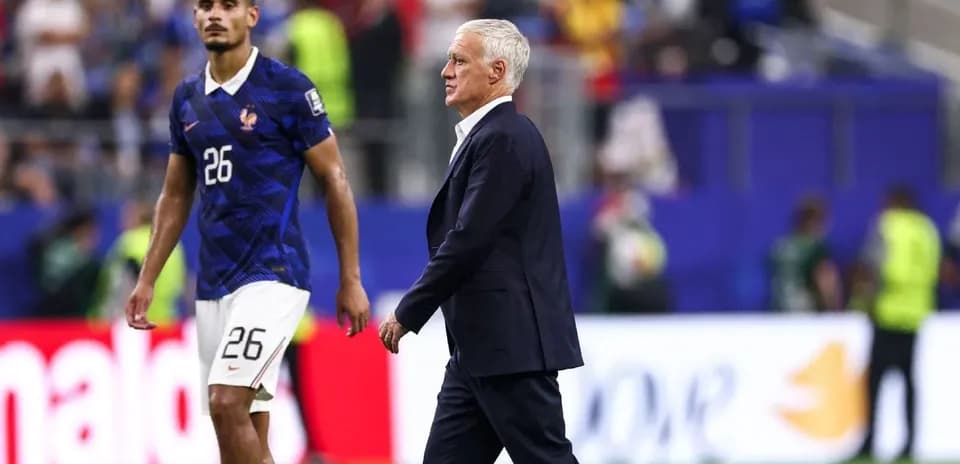Entrenador de Francia camina junto a jugador en el campo