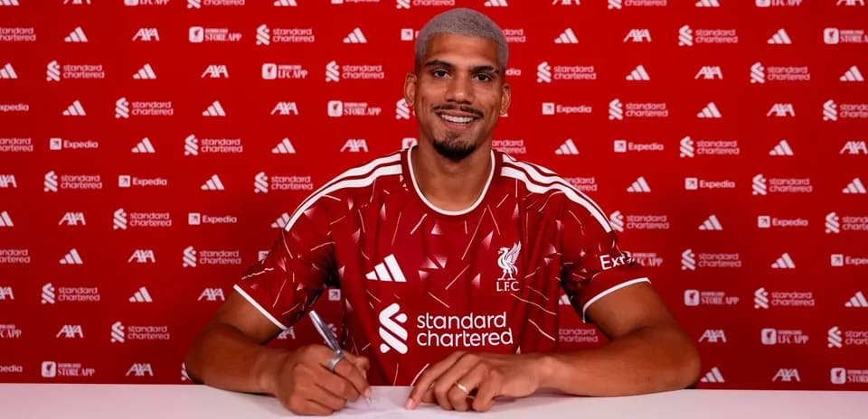 Jugador de Liverpool firmando contrato en mesa
