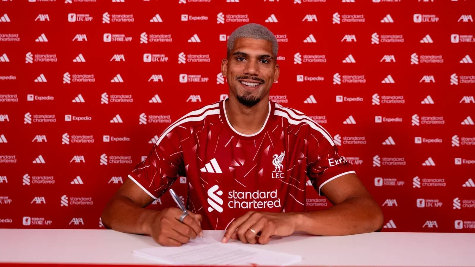 Jugador de Liverpool firmando contrato en mesa