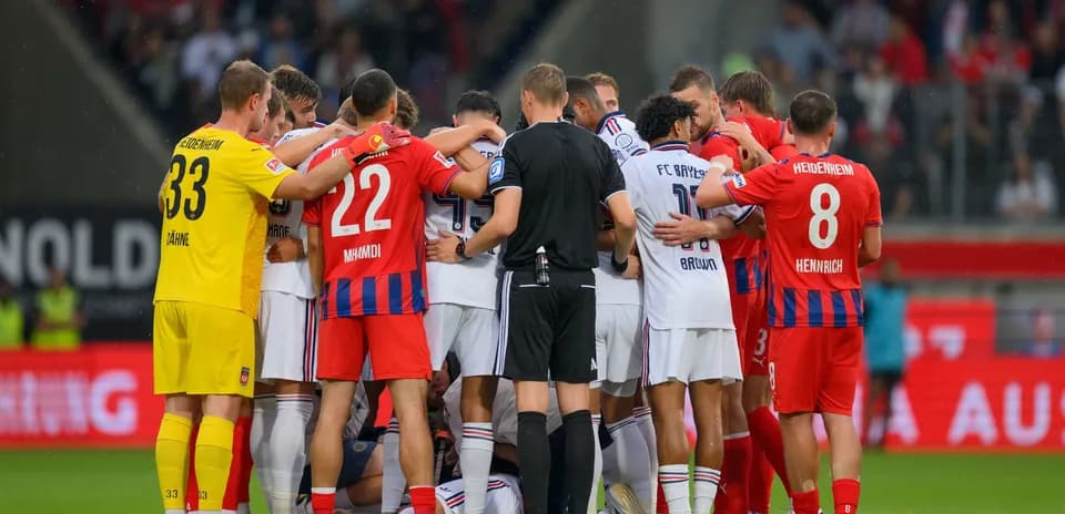 Jugadores de dos equipos en huddle durante partido