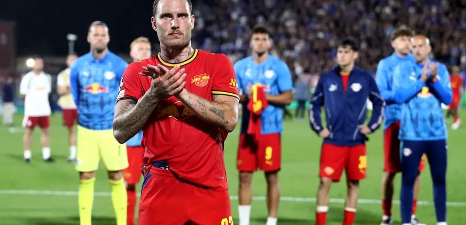 Jugador aplaudiendo en el campo con compañeros atrás